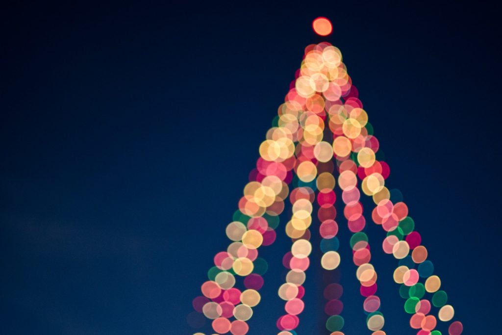 Das verschwommene Abbild eines Christbaums mit Weihnachtsbeleuchtung
