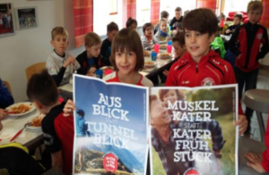 Kinder des FC Judenburg halten Sujets der Initiative "Mehr vom Leben"