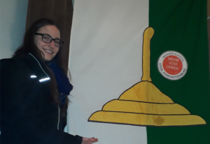 Eine Frau vor der Flagge des Eisschützenbunds der Holzstockschützen