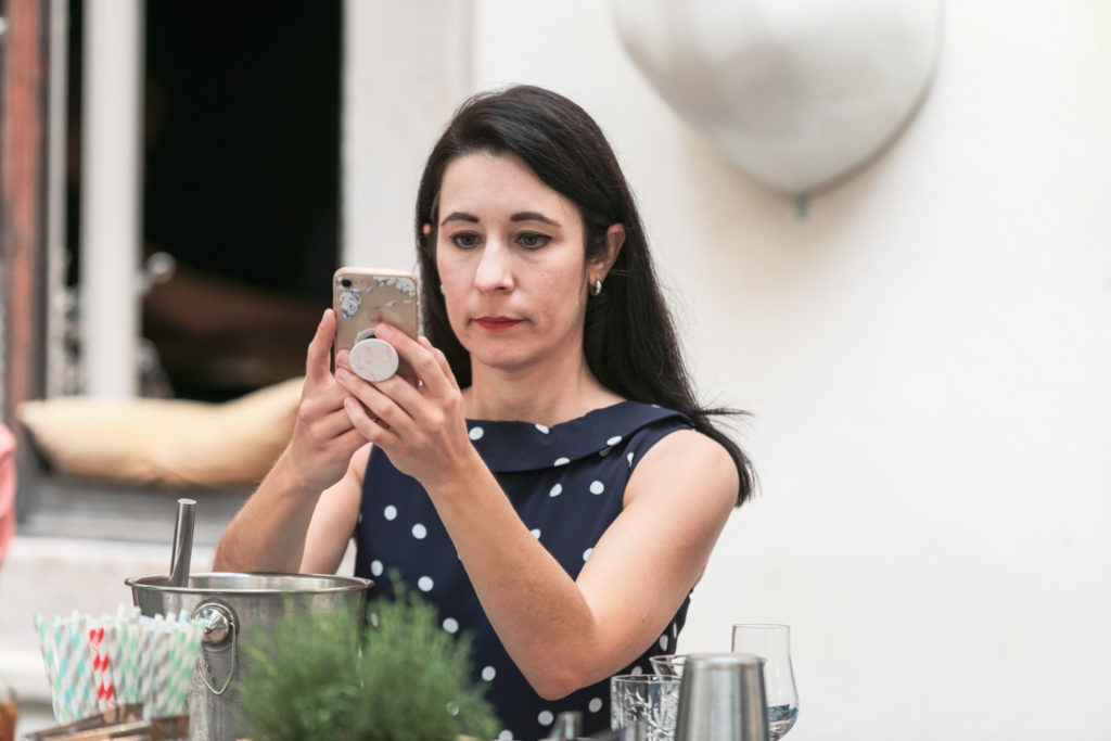 Frau mittleren Alters fotografiert mit ihrem Handy