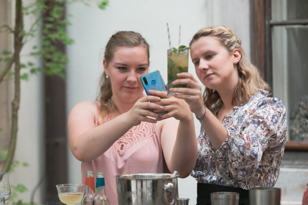 Zwei Frauen mittleren Alters fotografieren einen Mocktail