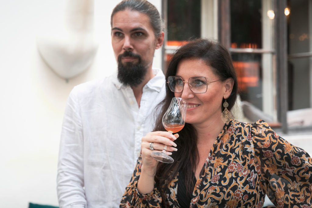 Mann mittleren Alters und Frau mittleren Alters, die ein Glas zum Mund führt.  