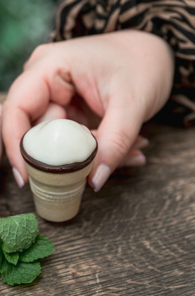 Ein Verjus Shot in einem Miniatur-Eisbecher mit Schokoladenfüllung