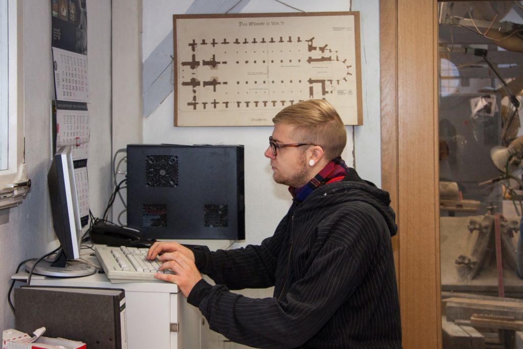 Mann frühen alters sitzt vor seinem PC