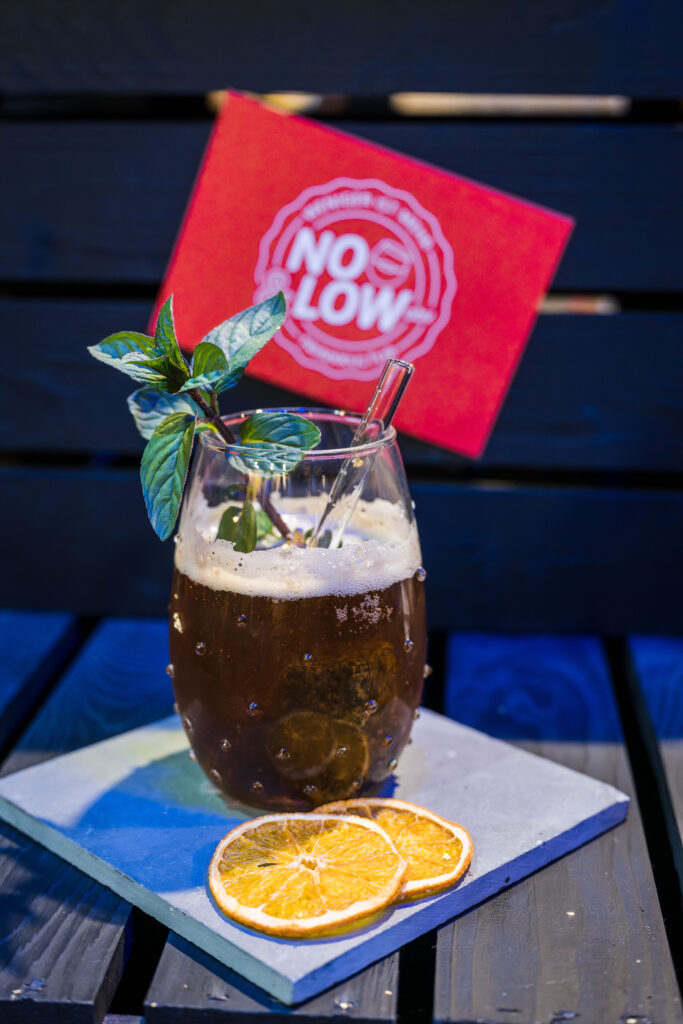 Ein Drink ohne Alkohol, verziert mit einem Strohhalm aus Glas und zwei Scheiben Orange. 