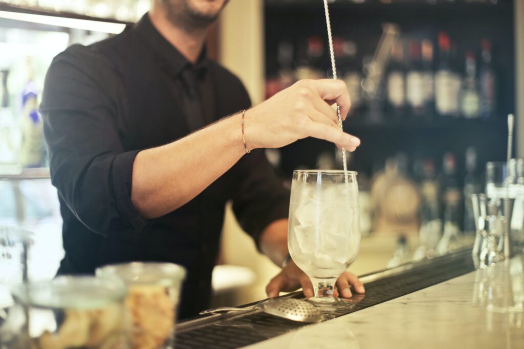 Mann mittleren Alters mixt einen Cocktail. 