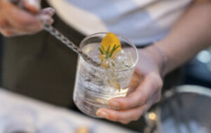 Cocktail mit weißer Flüssigkeit und Orangenscheibe als Garnierung